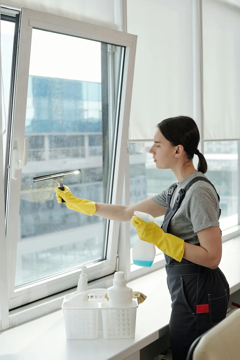 Person cleaning an office window with a squeegee