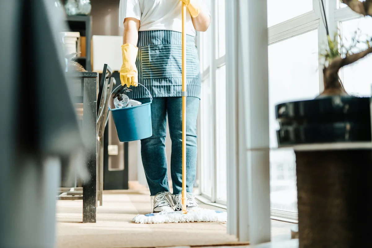 Person mopping the floor in a bright home